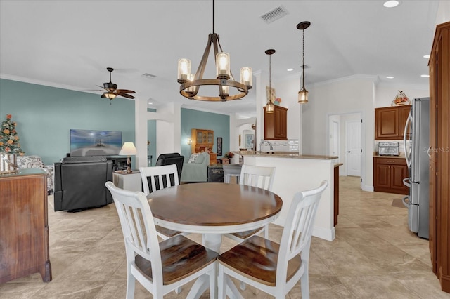 dining space featuring sink, ceiling fan with notable chandelier, vaulted ceiling, and ornamental molding