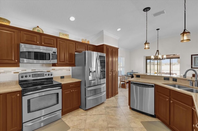 kitchen featuring a healthy amount of sunlight, stainless steel appliances, sink, and hanging light fixtures