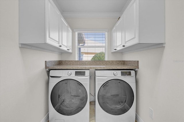 laundry room with cabinets, crown molding, and separate washer and dryer