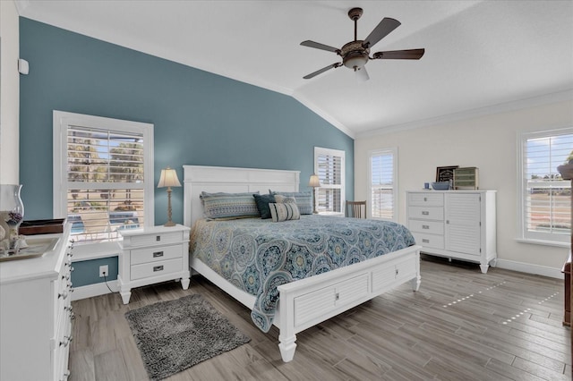 bedroom with crown molding, vaulted ceiling, ceiling fan, and light wood-type flooring