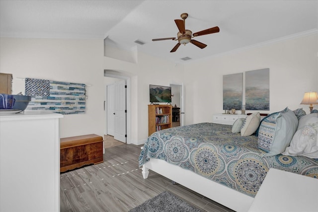 bedroom with hardwood / wood-style flooring, ceiling fan, lofted ceiling, and crown molding