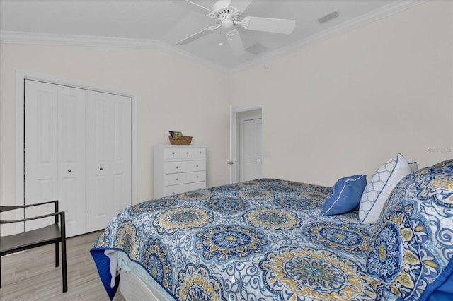 bedroom with hardwood / wood-style floors, lofted ceiling, ceiling fan, crown molding, and a closet