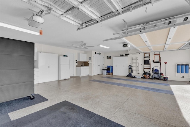 garage with white refrigerator, sink, and a garage door opener