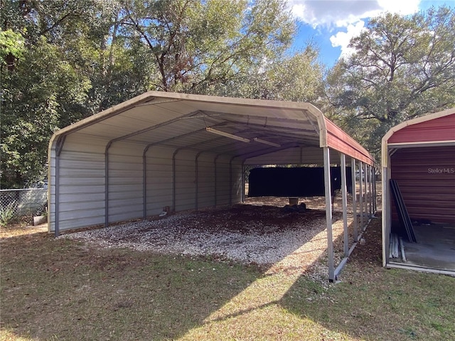 view of vehicle parking with a carport, fence, and driveway