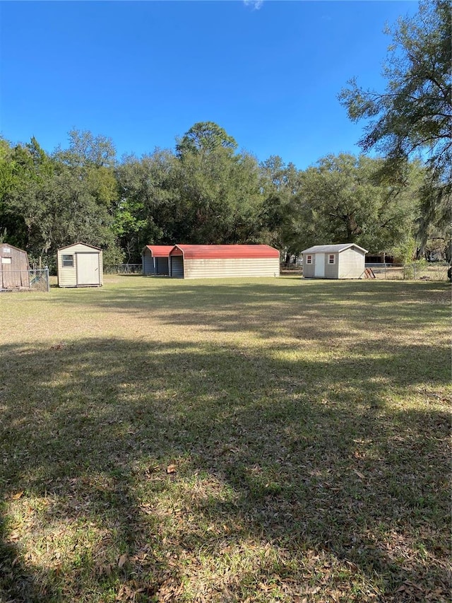 view of yard featuring an outdoor structure, a storage shed, and fence