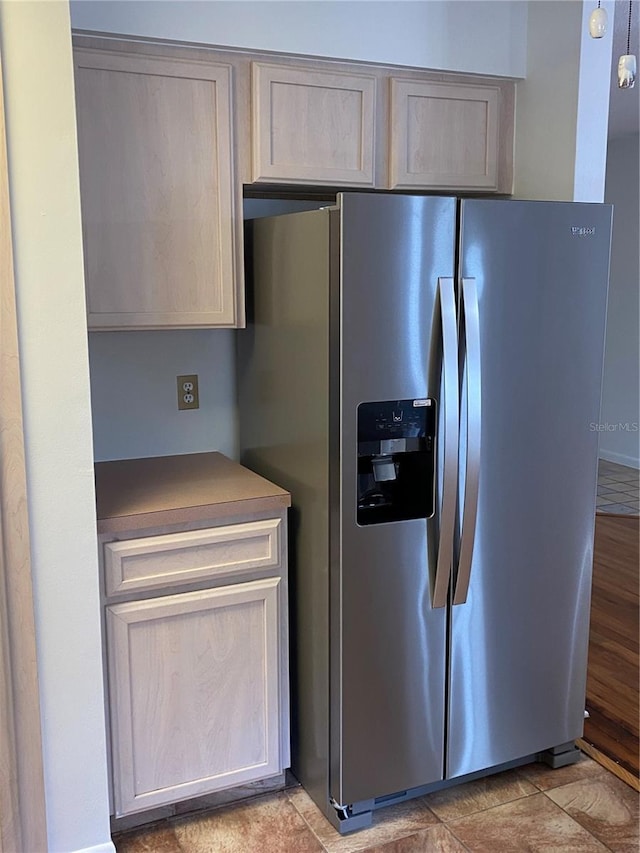 kitchen with light brown cabinets and stainless steel fridge with ice dispenser