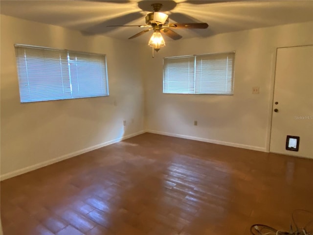 empty room with ceiling fan, baseboards, and wood finished floors