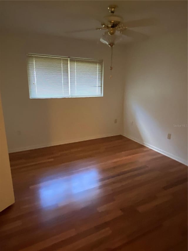 empty room featuring a ceiling fan and wood finished floors