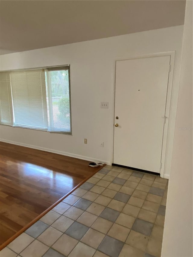 foyer entrance with light wood-type flooring and baseboards