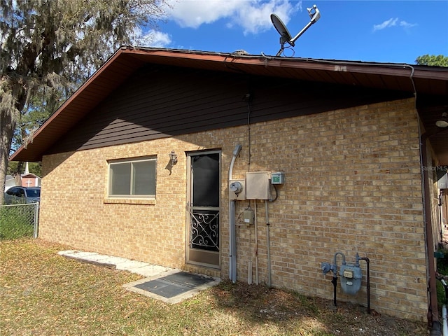 back of house with brick siding and fence