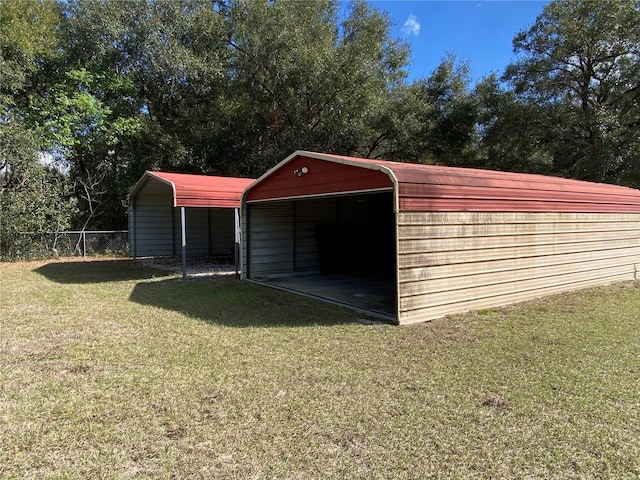 view of outdoor structure with a carport and fence