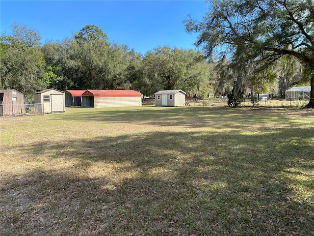 view of yard with fence, a storage unit, and an outdoor structure