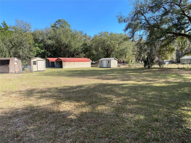 view of yard with an outbuilding, fence, and a shed