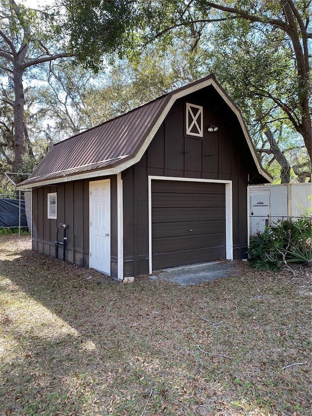 detached garage featuring driveway and fence