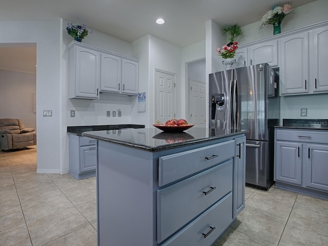 kitchen with gray cabinets, light tile patterned flooring, a center island, and stainless steel fridge