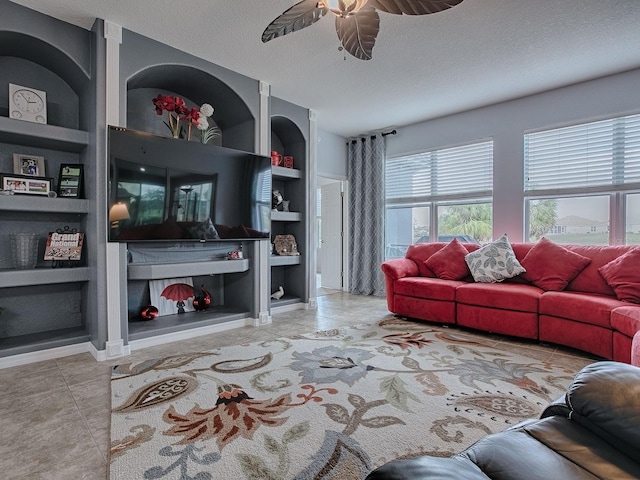 tiled living room with ceiling fan, a textured ceiling, and built in shelves