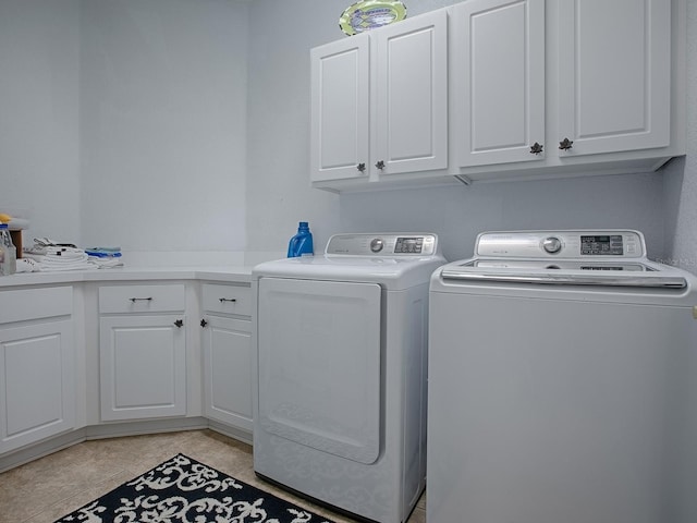 washroom featuring independent washer and dryer, cabinets, and light tile patterned flooring