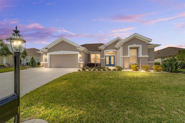 view of front of property featuring concrete driveway, an attached garage, french doors, a front lawn, and stucco siding