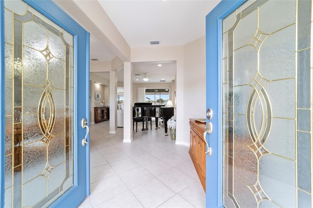 foyer entrance featuring visible vents, ceiling fan, baseboards, and light tile patterned flooring