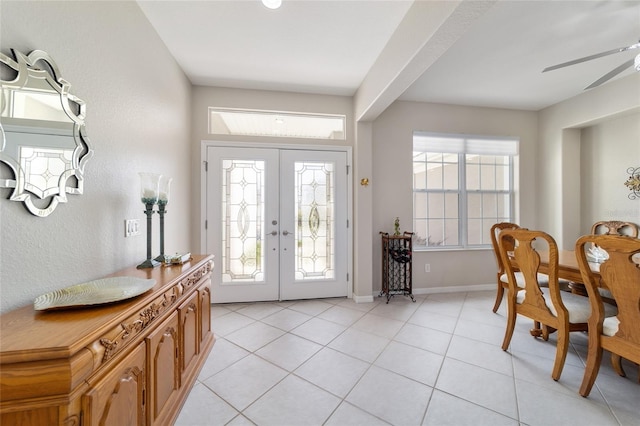 foyer featuring a ceiling fan, french doors, baseboards, and light tile patterned floors