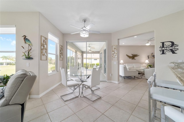 dining space with light tile patterned floors, ceiling fan, and baseboards