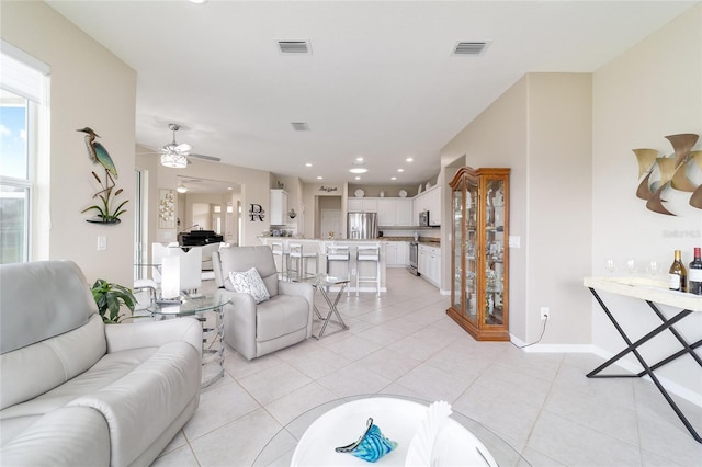 living area featuring light tile patterned floors, visible vents, and recessed lighting