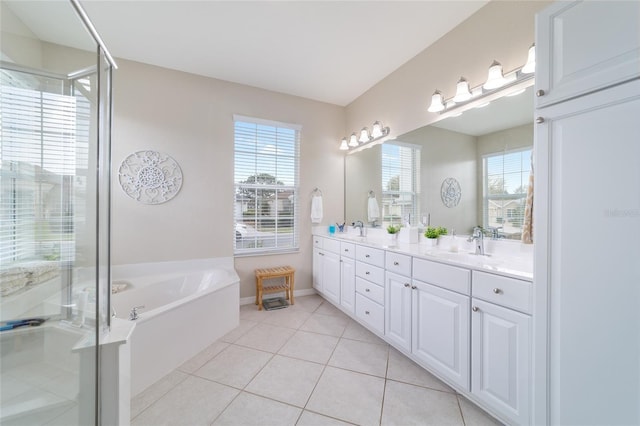 full bathroom featuring a stall shower, a garden tub, a sink, and tile patterned floors