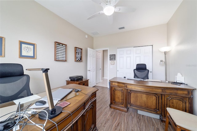 home office featuring light wood finished floors, visible vents, and a ceiling fan