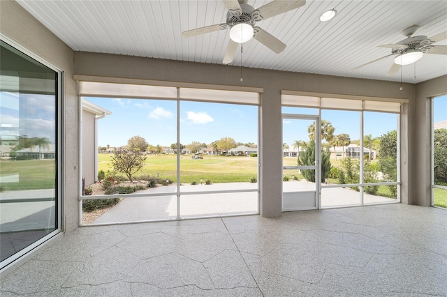 unfurnished sunroom featuring a ceiling fan and a healthy amount of sunlight