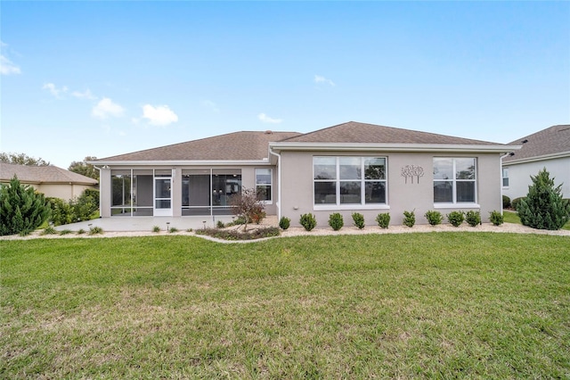 rear view of property with a sunroom, stucco siding, and a yard