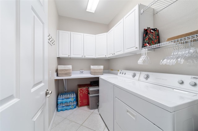 clothes washing area featuring light tile patterned flooring, cabinet space, and separate washer and dryer