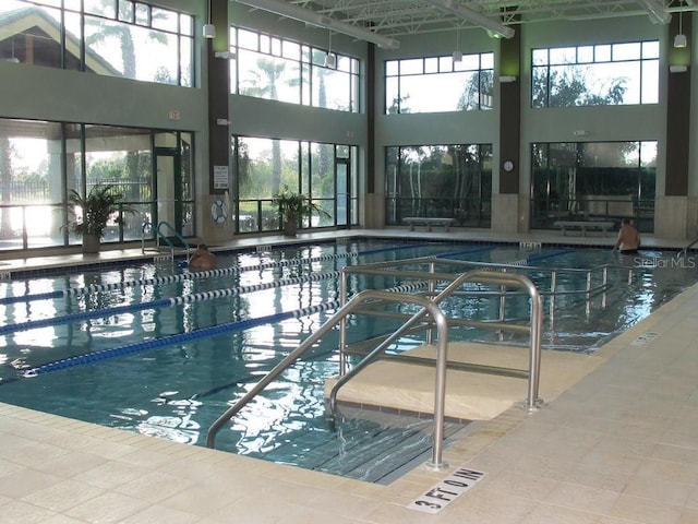 community pool with glass enclosure and a patio