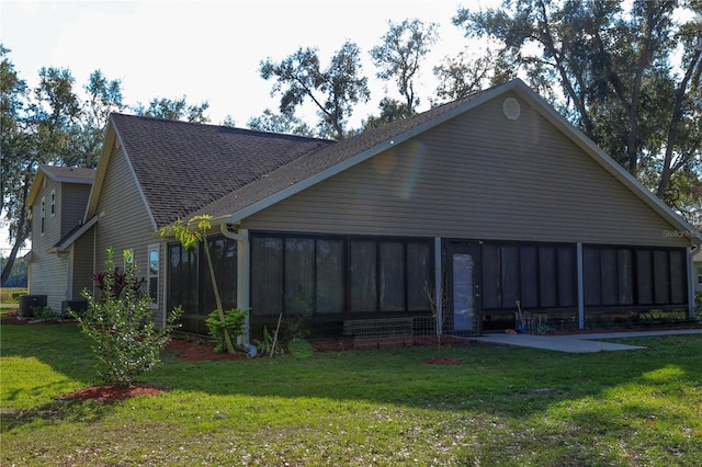 rear view of property featuring a lawn, a sunroom, and cooling unit