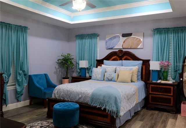 bedroom featuring a tray ceiling, ornamental molding, ceiling fan, and hardwood / wood-style floors