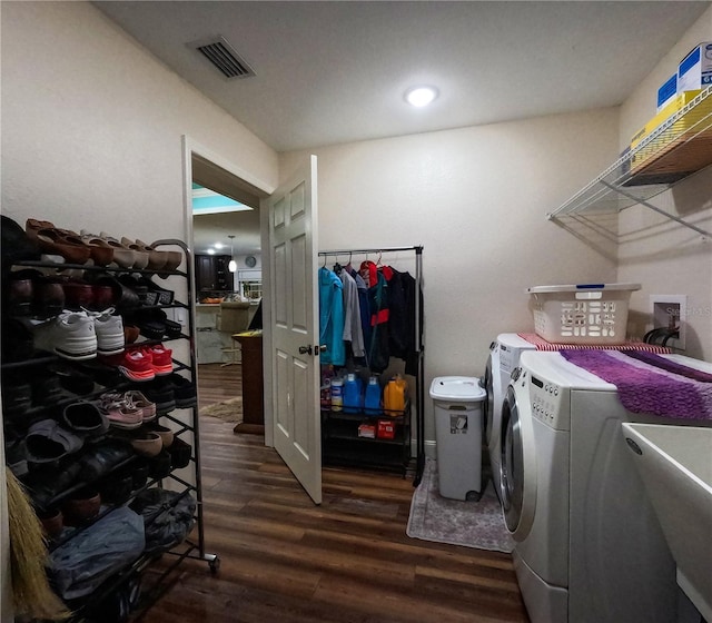 washroom with washer and dryer, dark wood-type flooring, and sink