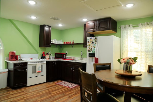 kitchen featuring sink, white appliances, dark brown cabinets, and light hardwood / wood-style flooring