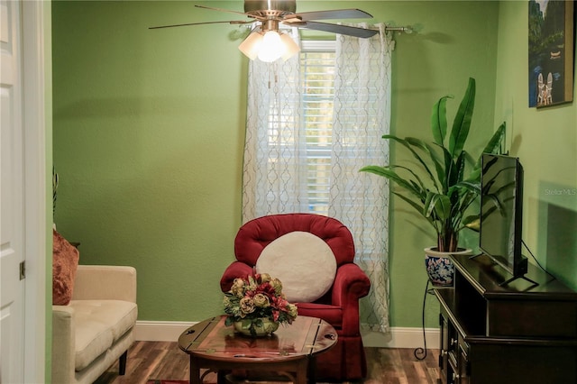 living area with dark wood-type flooring and ceiling fan