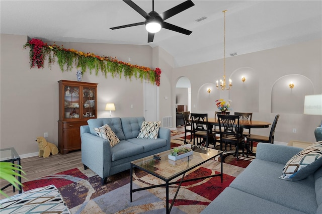 living room with wood finished floors, arched walkways, visible vents, and lofted ceiling