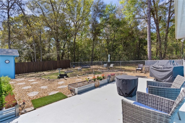 view of patio / terrace featuring an outbuilding, a fenced backyard, and a shed