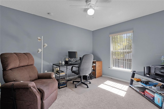 office space featuring a textured ceiling, baseboards, carpet floors, and ceiling fan