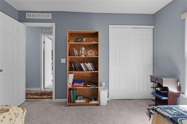 carpeted bedroom featuring visible vents, baseboards, and a closet