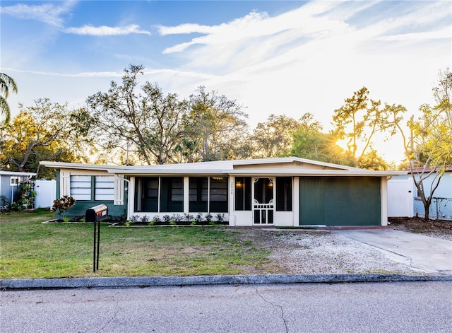 single story home with a sunroom and a front lawn