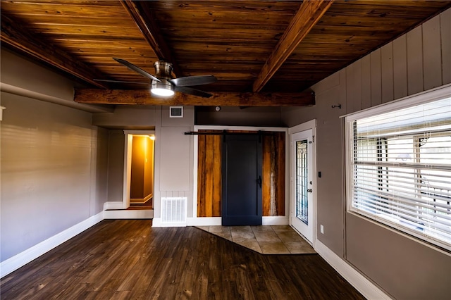 interior space featuring beam ceiling, wood-type flooring, wooden ceiling, and a barn door