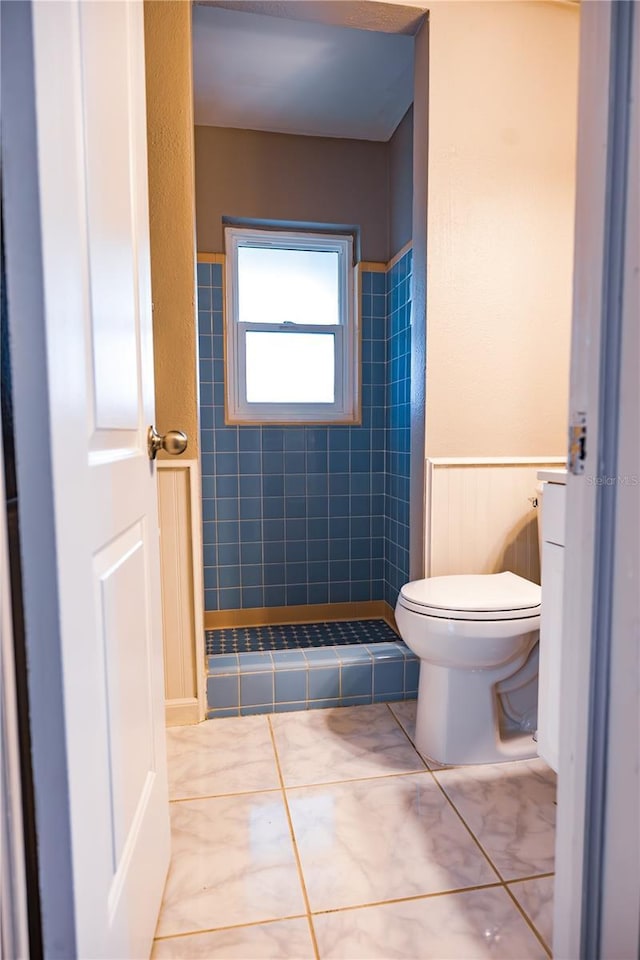 bathroom with tiled shower and toilet