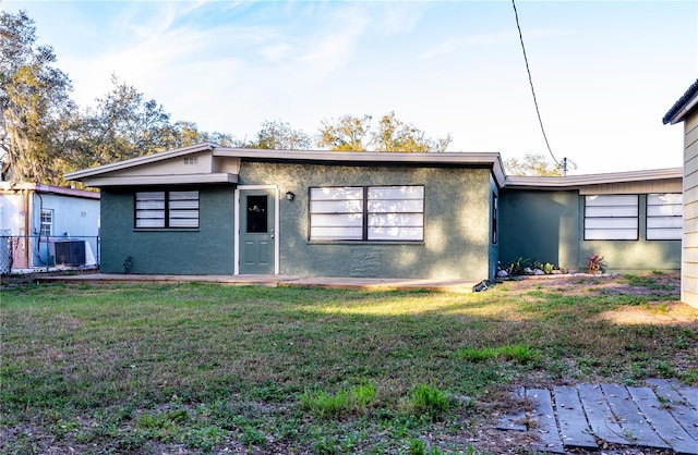 single story home featuring central AC and a front lawn