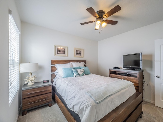 bedroom featuring light carpet, ceiling fan, and baseboards