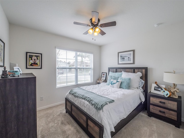 bedroom featuring light carpet, ceiling fan, and baseboards