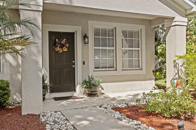view of exterior entry with stucco siding