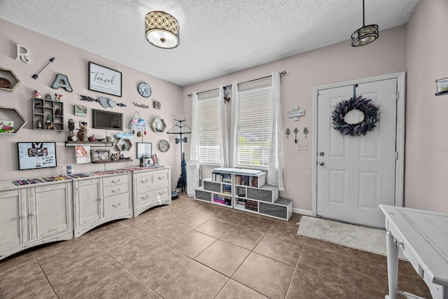 entryway with a textured ceiling and tile patterned flooring