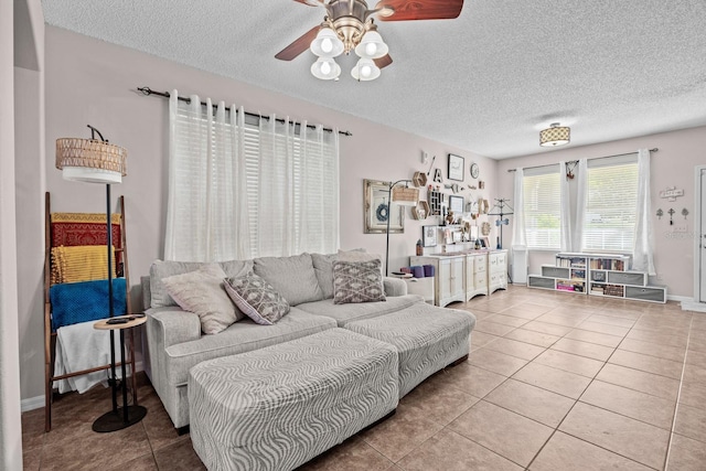 living area featuring ceiling fan, tile patterned flooring, and a textured ceiling